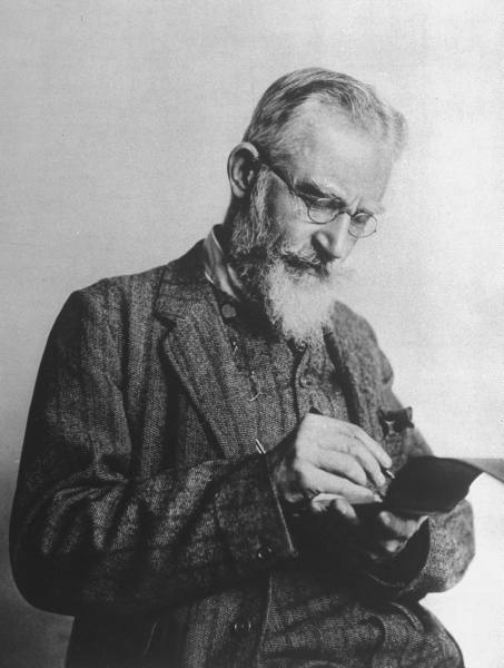 Anglo-Irish playwright George Bernard Shaw (1856-1950) writing in notebook at time of first production of his play "Pygmalion." (LIFE)