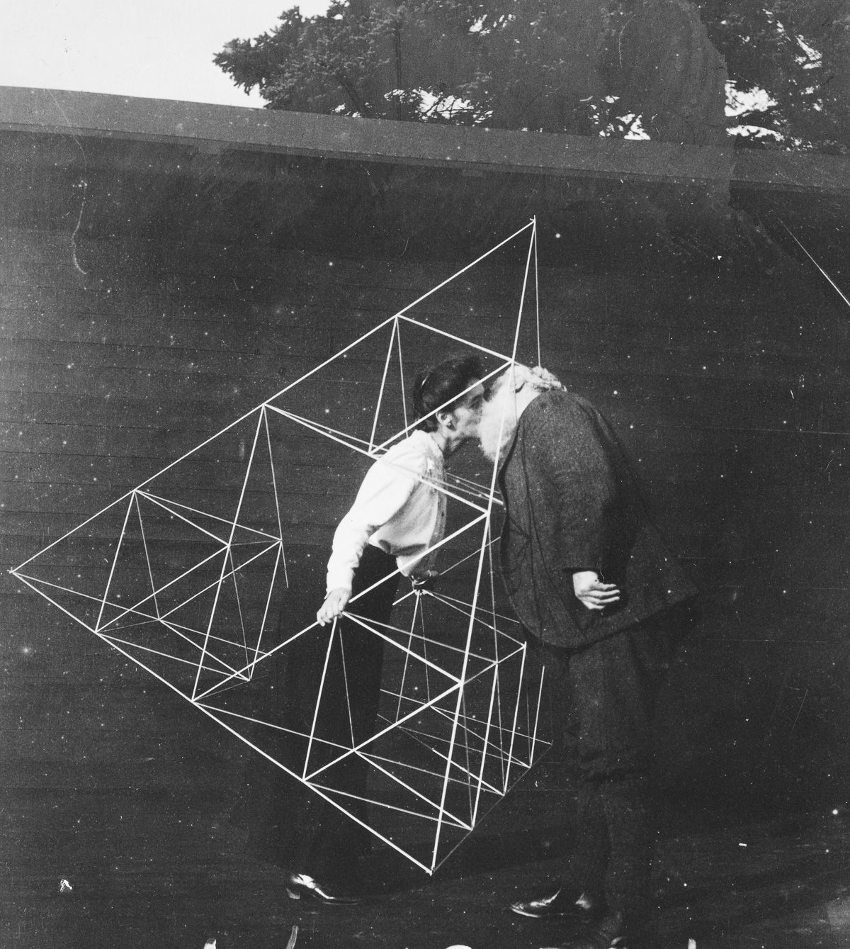 Alexander Graham Bell kisses his wife inside a tetrahedral framework, 1903